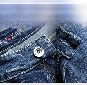Detailed macro view of the silver metal button and zipper on these denim shorts