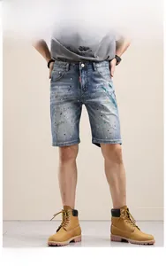 Détail d'un short en jean bleu avec des touches de peinture colorée et une finition usée chic