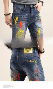 Detail view of denim texture with vibrant red, yellow and white paint splatter patterns