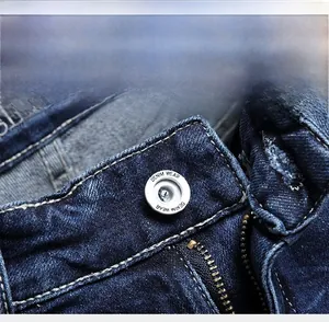 Detail of silver metal button and zipper on heavy-duty blue denim shorts for men