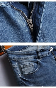Detail view of denim fabric texture with YKK metal zipper and silver button