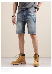Détails du short en jean bleu avec des éclaboussures de peinture et moustaches délavées