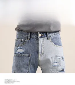 Detailed close-up of patched denim shorts featuring frayed edges and vintage waist design