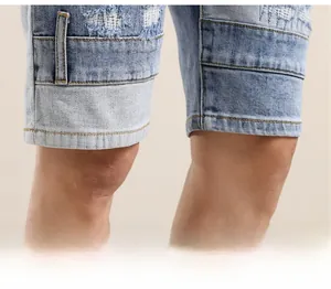 Detailed close-up of distressed denim shorts hem with frayed edges and vintage patchwork