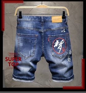 Detail der Stickerei und des Lederetiketts an blauen Herren-Denim-Shorts