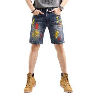 Men's denim shorts with colorful paint splatter print on medium blue cotton fabric