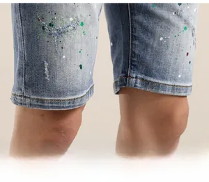 Gros plan sur un short en jean avec éclaboussures de peinture et ourlet effet usé
