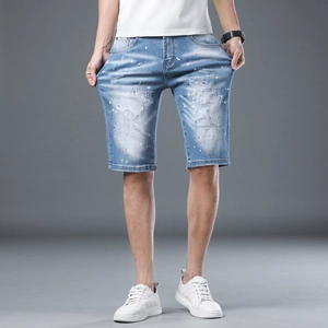 Men's light blue denim shorts with distressed holes and paint splatter street style