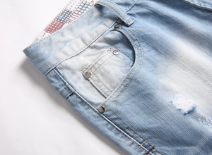 Detail of light blue denim shorts featuring a vintage wash and American flag print lining
