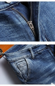 Detail of blue denim shorts showing the YKK metal zipper and washed fabric texture