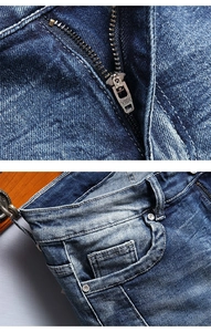 Detailed macro view of YKK metal zipper and reinforced rivets on blue denim jeans