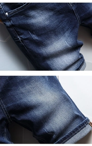 Detailed close-up of dark blue washed denim fabric with subtle distressed textures