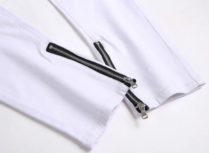Detailed macro view of white slim-fit jeans featuring metallic side zipper at the hem cuffs
