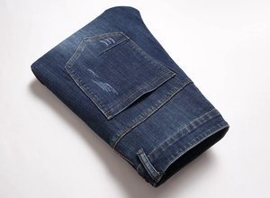 Gros plan sur un jean bleu montrant les coutures jaunes et la texture de la poche
