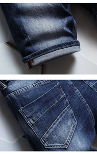 Close-up of washed denim shorts featuring whiskering effects and folded cuffs
