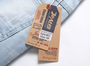 Detailed macro view of light blue denim waist and dual tags on men's distressed shorts