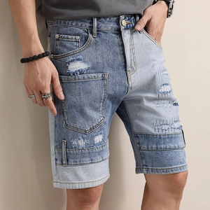 Men's denim shorts with patchwork design and distressed ripped details in blue
