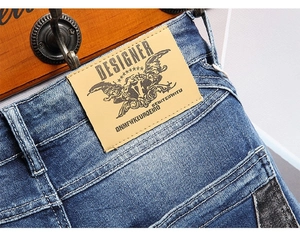 Macro shot of vintage mid-blue denim shorts featuring leather brand tag and contrast stitching