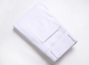 Detail view of white stretch denim pants showing twill fabric texture and pocket stitching