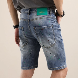 Short en jean pour homme avec taches de peinture colorées et étiquette en cuir verte