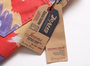Makroaufnahme von Vintage-Papierschildern auf Jeans mit buntem Graffiti-Aufdruck