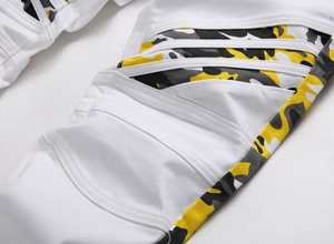 Détail de jean blanc avec empiècements matelassés aux genoux et motifs camouflage