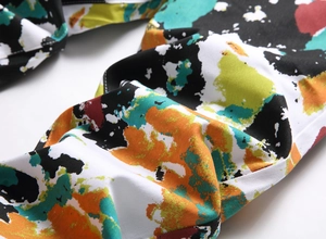 Detailed close-up of slim fit denim fabric featuring vibrant colorful graffiti patterns