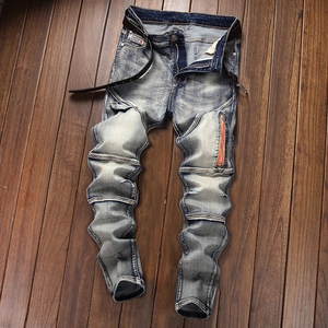 Detail of acid wash denim jeans with stacked pleats and orange decorative zipper on leg