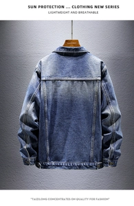 Detail view of the back of a blue washed denim jacket with vintage stitching and loose fit