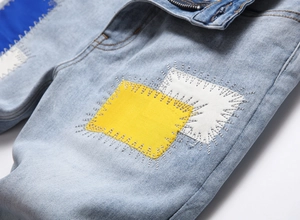Close-up of distressed denim with colorful patchwork and intricate stitching details