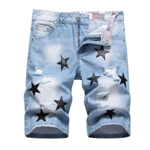 Men's light blue ripped denim shorts with black leather star patches and distressed details