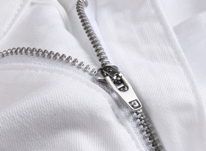 Detail des silbernen Metallreißverschlusses und des weißen Baumwolltwills der Jeans