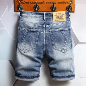 Men's mid-blue washed denim shorts with vintage distressed fade and five-point cut