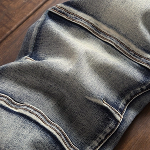 Detail of vintage indigo biker jeans featuring pleated accordion panels and double stitching