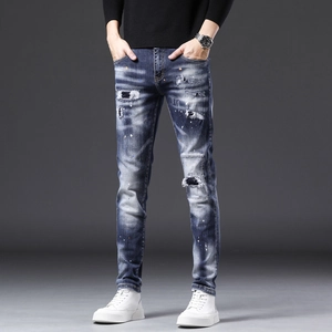 Détails de jeans en denim bleu délavé avec déchirures faites main et taches de peinture