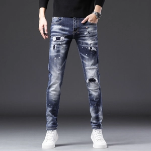 Détail d'un jean bleu ajusté pour homme avec patchwork et motifs de taches de peinture