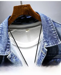 Detail of blue denim jacket collar with size S label and black woven necklace