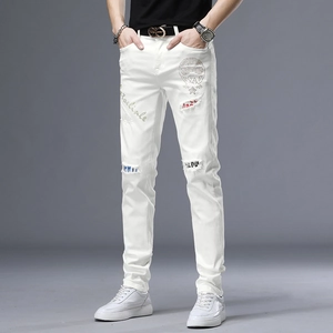 Détails du jean blanc pour homme avec motif de crâne en strass et broderies de mode