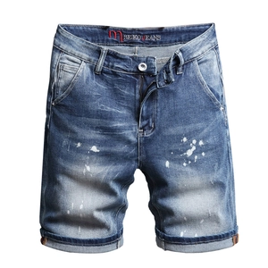 Men's mid-waist stretch denim shorts with distressed paint splatter and whiskers