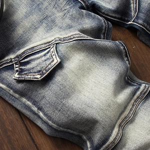 Detailed macro view of blue washed denim fabric with double-stitched seams and workwear pocket