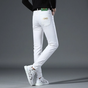 Detail of slim fit white jeans for men featuring gold logo on the back pocket area