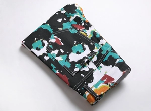 Close-up of folded slim fit jeans with colorful abstract paint splatter print details