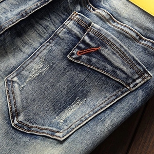 Slim fit blue denim jeans with vintage wash and orange embroidery detail on the back pocket