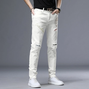Détail du jean slim blanc avec écussons brodés et imprimés de style urbain pour hommes