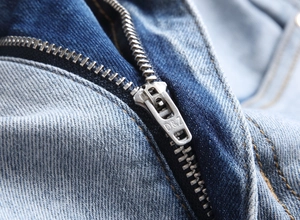 Macro view of a durable alloy zipper with D&Z engraving on blue slim fit jeans