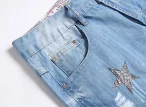Detailed close-up of light blue denim shorts with star embroidery and ripped street style