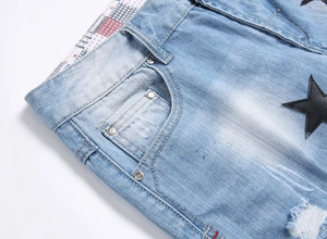 Detailed macro view of light blue denim fabric with star patch and frayed edges