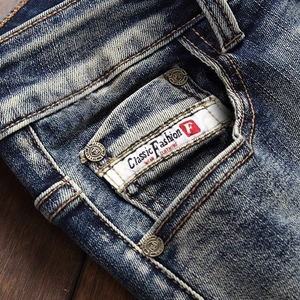 Detailed macro view of vintage washed denim jeans featuring precise stitching and rivets