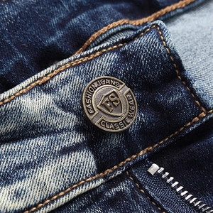 Macro detail of dark blue denim with vintage metal button and sturdy zipper closure