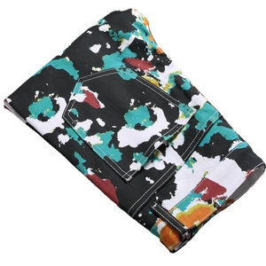 Men's slim fit stretch jeans with vibrant colorful paint splatter print on black fabric